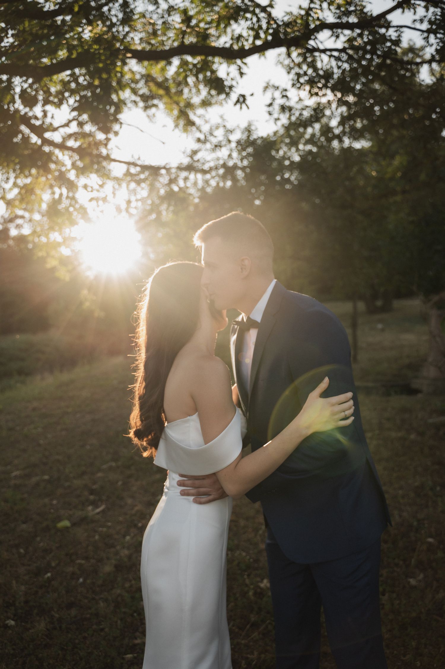 Romantic sunset portrait of couple embracing in golden evening light.