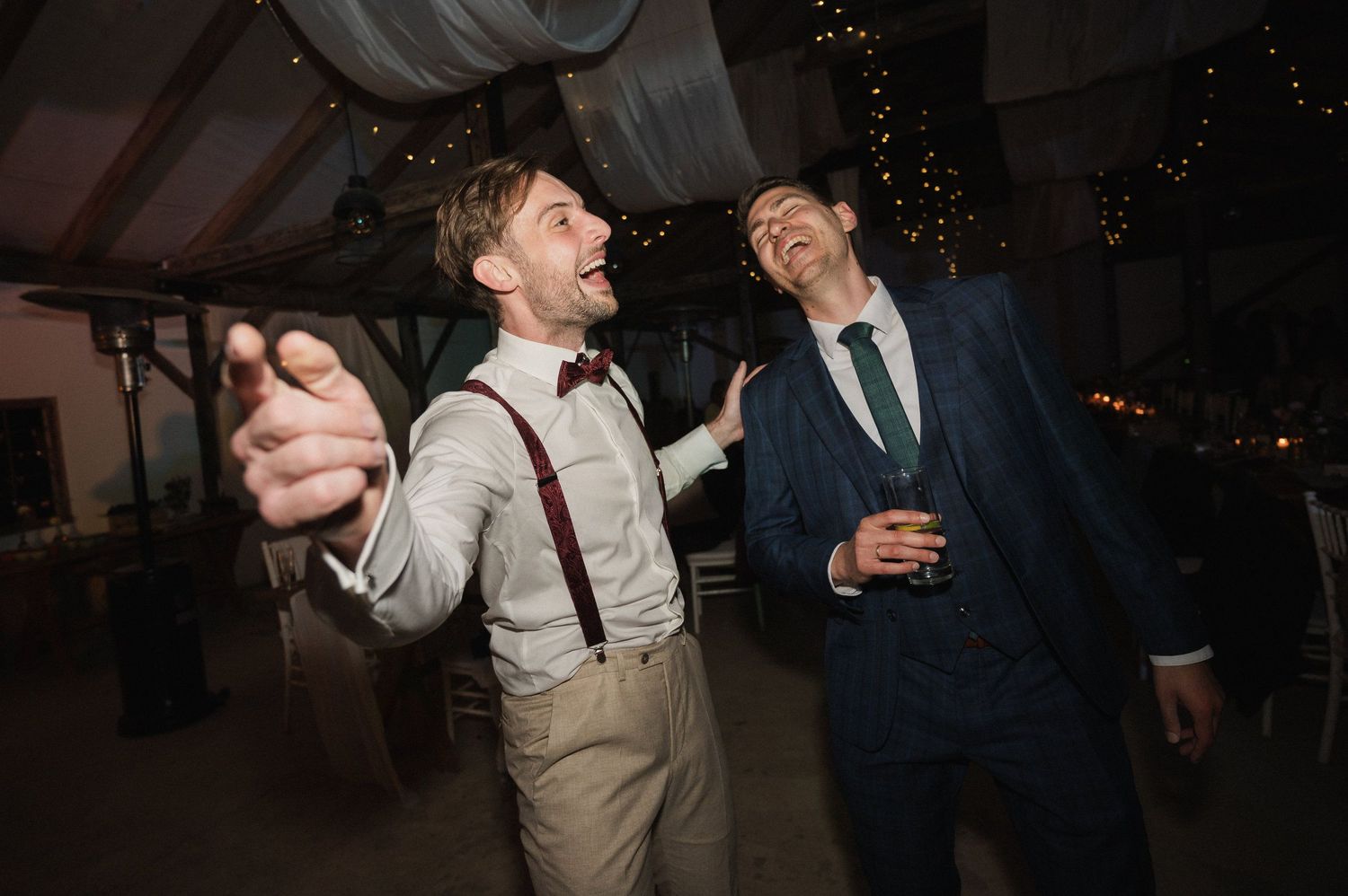 Wedding guests dancing and celebrating on the dance floor during an evening reception celebration.