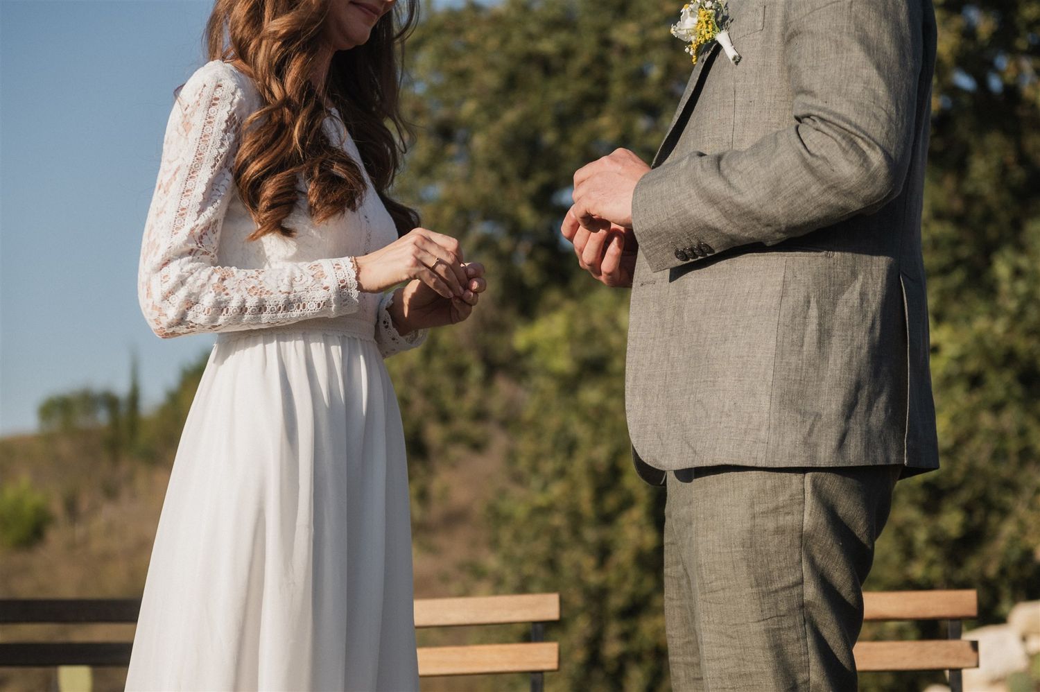 A couple shares a romantic moment outdoors with greenery in the background.
