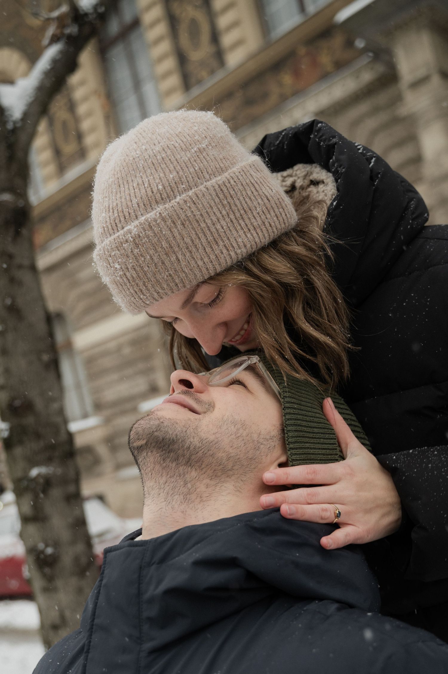 A tender winter moment shared between two people in knit hats.