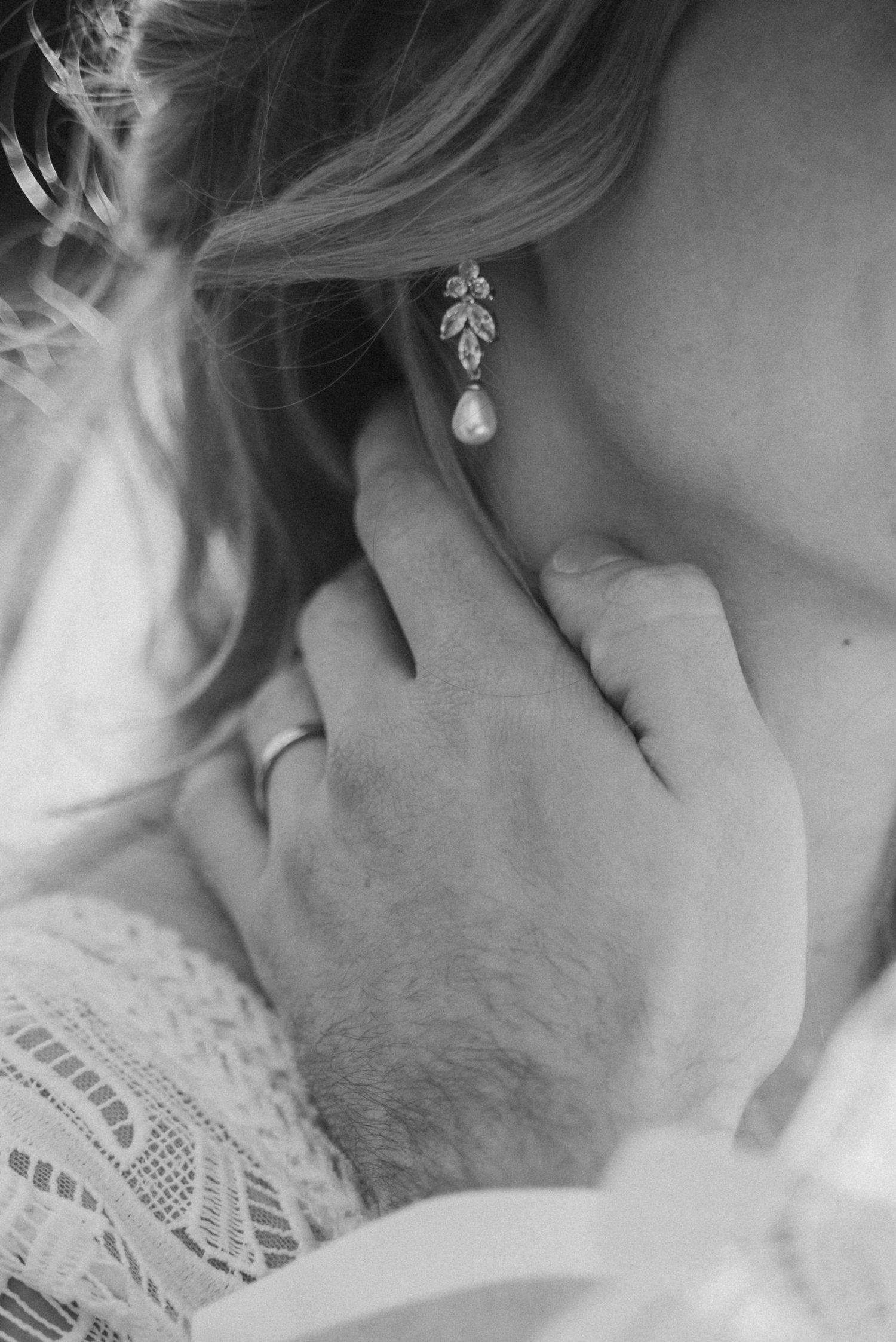 A romantic black and white close-up photo showing an intimate moment between a couple in delicate lace.