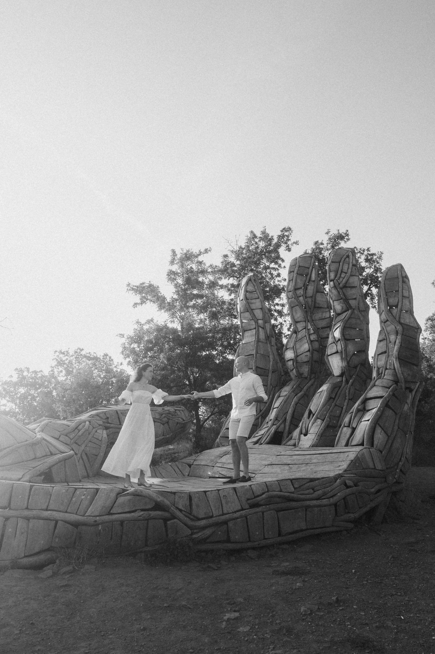 Vintage black and white photograph showing people standing on a sculptural rock formation in a natural setting.