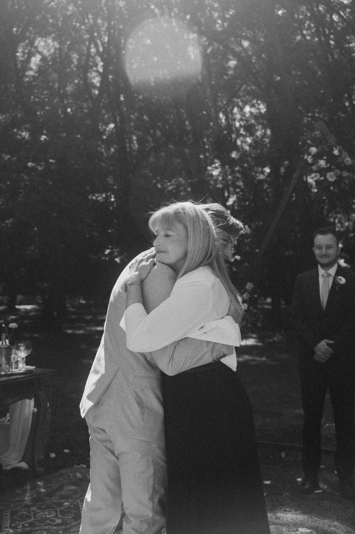 Black and white photo series showing a couple embracing and dancing together in an outdoor garden setting.