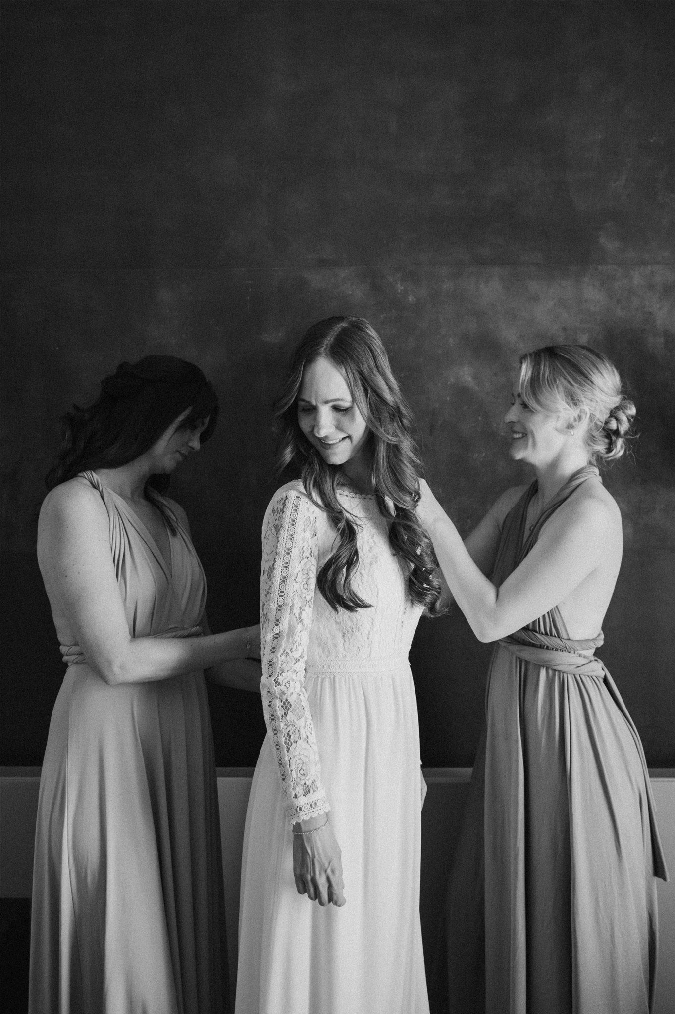 A group in sage green and white dresses pose together for a black and white portrait.