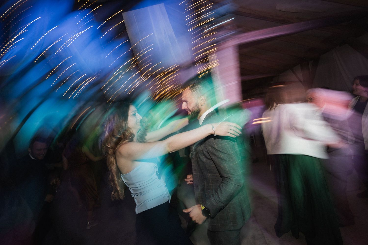 Abstract motion blur photography captures dynamic movement with blue and green lighting effects against dark background.