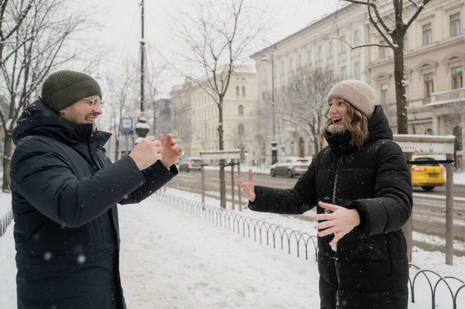 Two friends enjoying drinks and conversation on a snowy winter day.