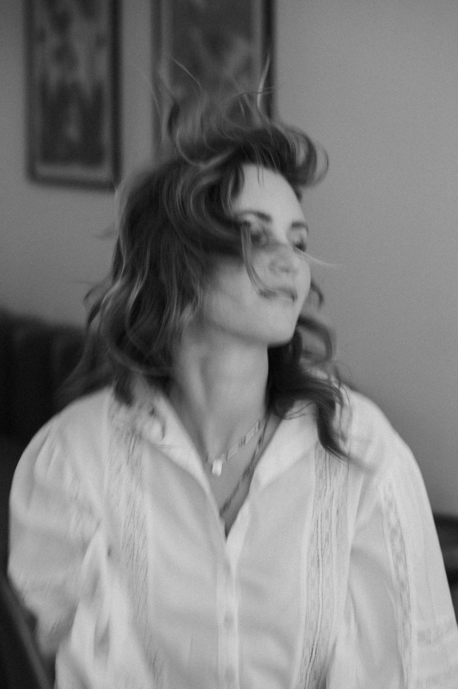 A black and white portrait of someone with flowing hair in motion.