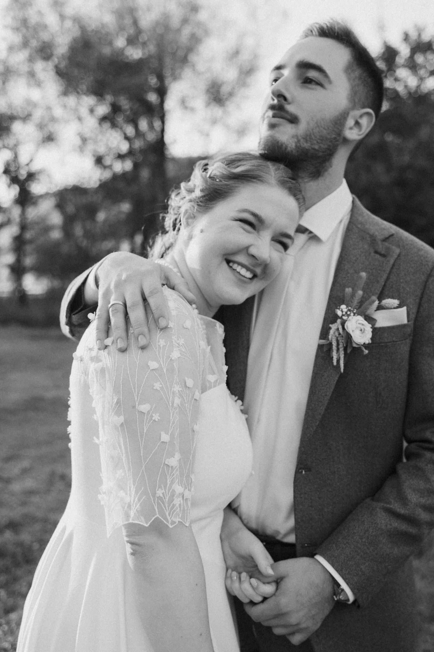 A couple shares joyful moments in black and white wedding photos showing natural laughter and candid expressions.