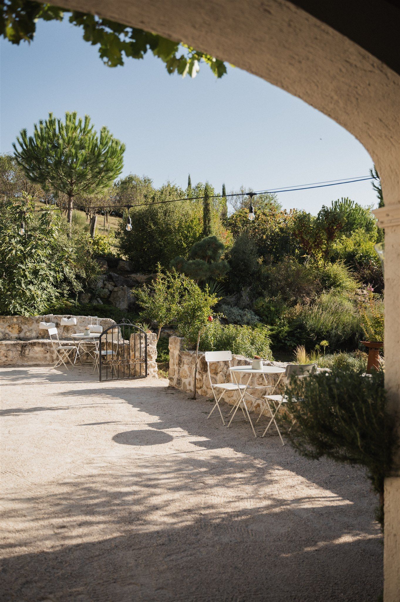 Empty outdoor reception area with scattered bistro tables under a covered patio.