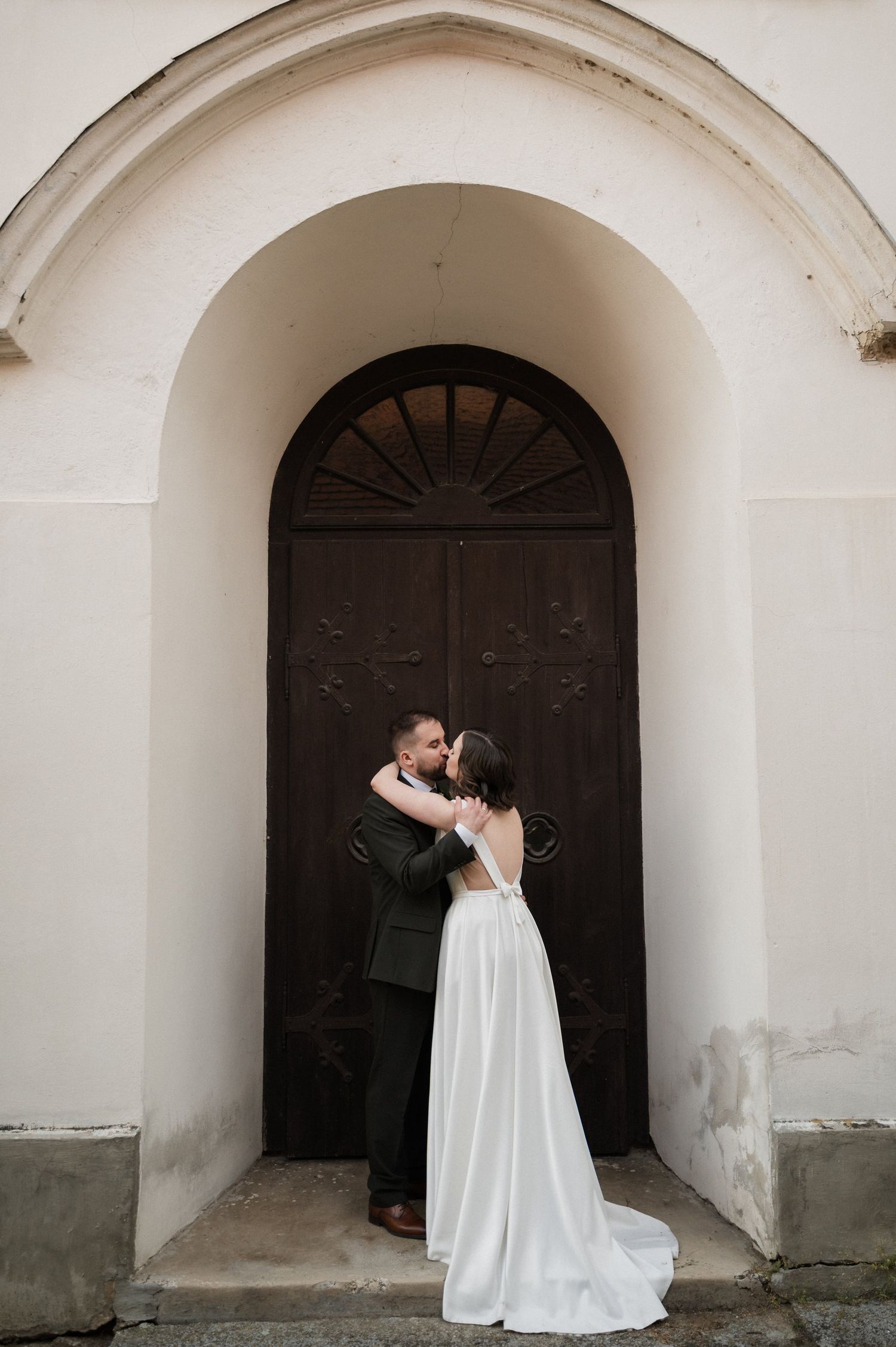 A romantic moment unfolds in a sequence of arched doorway photos showing a couple embracing in white wedding attire.
