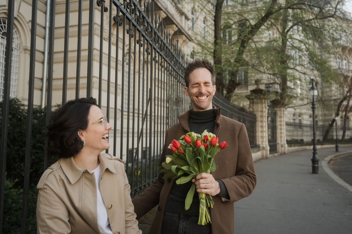 A series of four photos showing a romantic surprise proposal with flowers on an elegant city street.