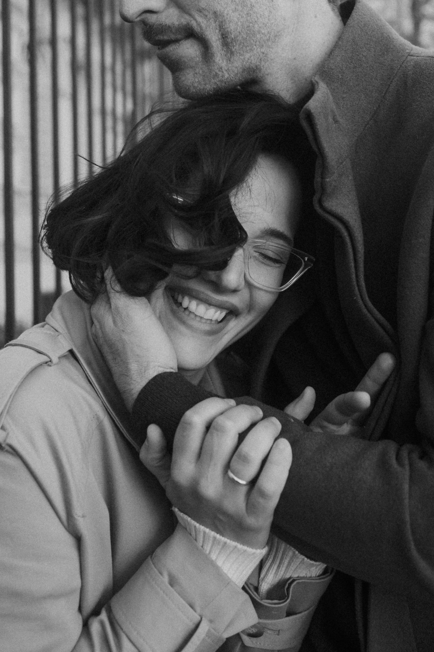 Black and white intimate portrait of a couple sharing a tender moment as they embrace and smile together.