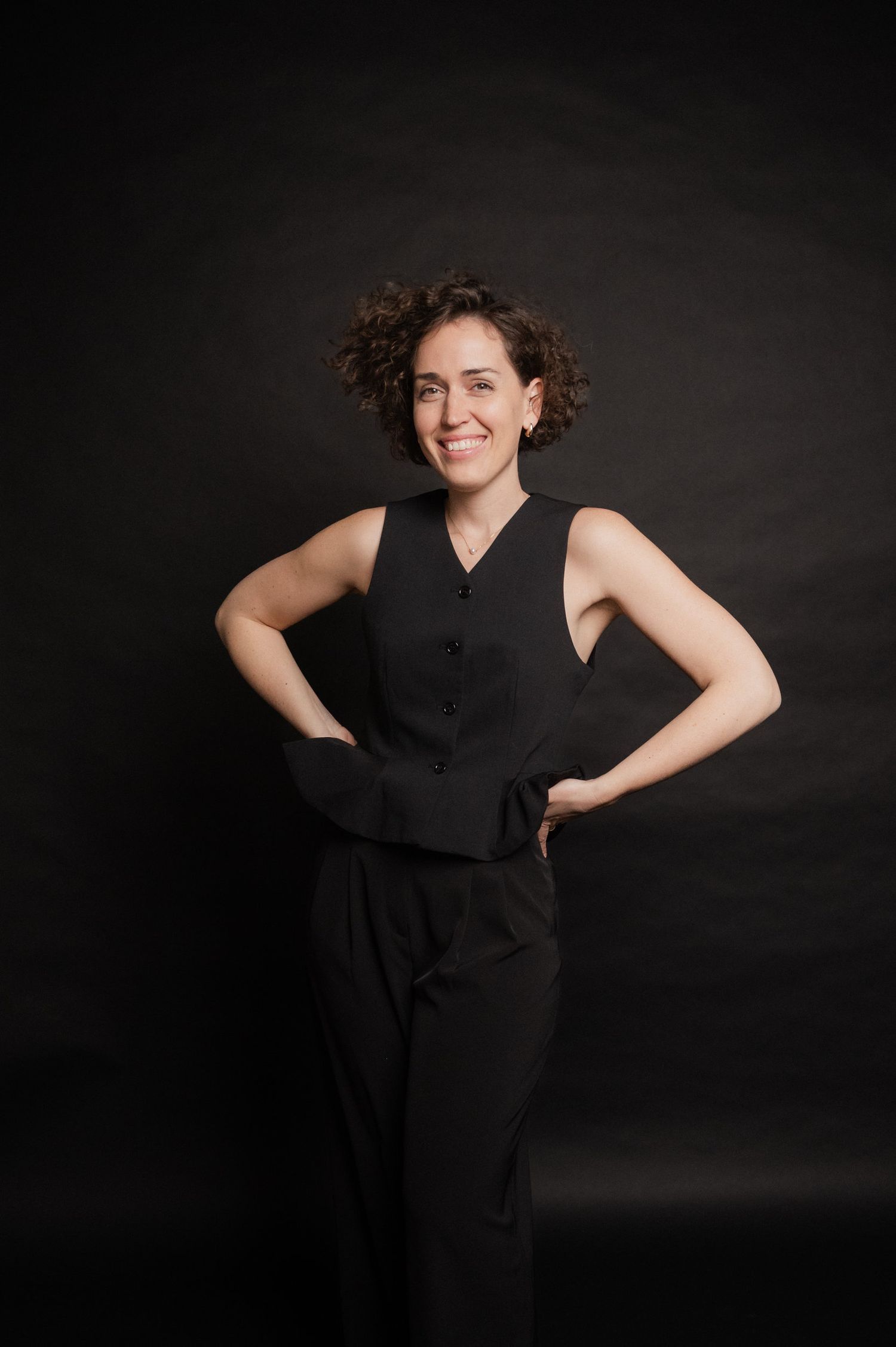 A figure in a black sleeveless dress poses elegantly against a dark background in a series of artistic portraits.