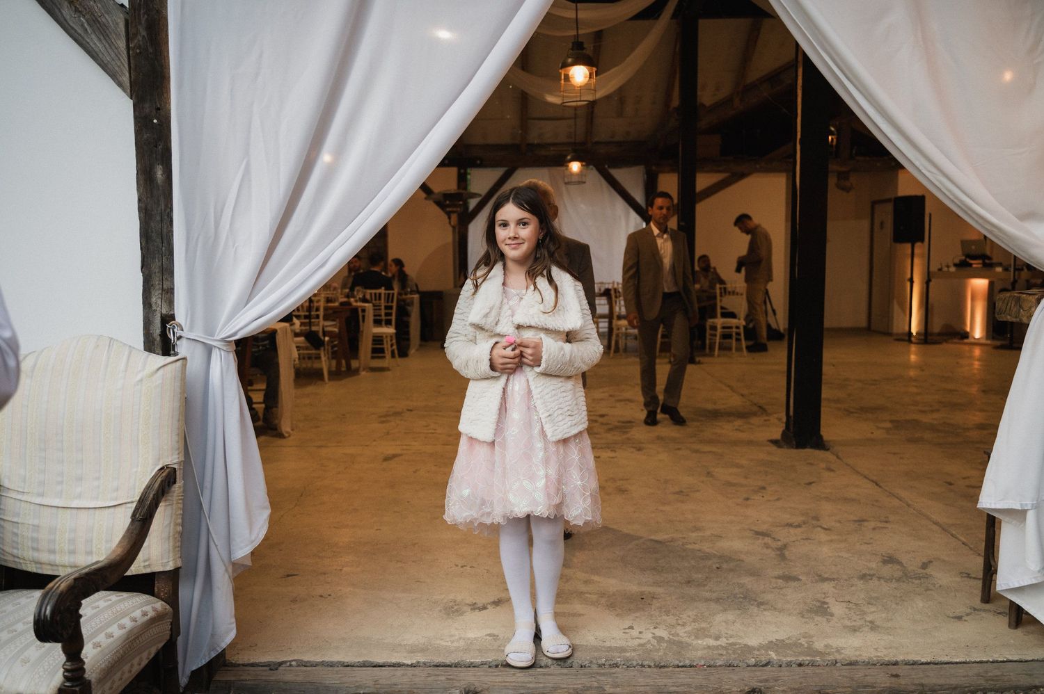 A series of connected photos showing a winter wedding celebration with white decor and flowing curtains in an indoor venue.
