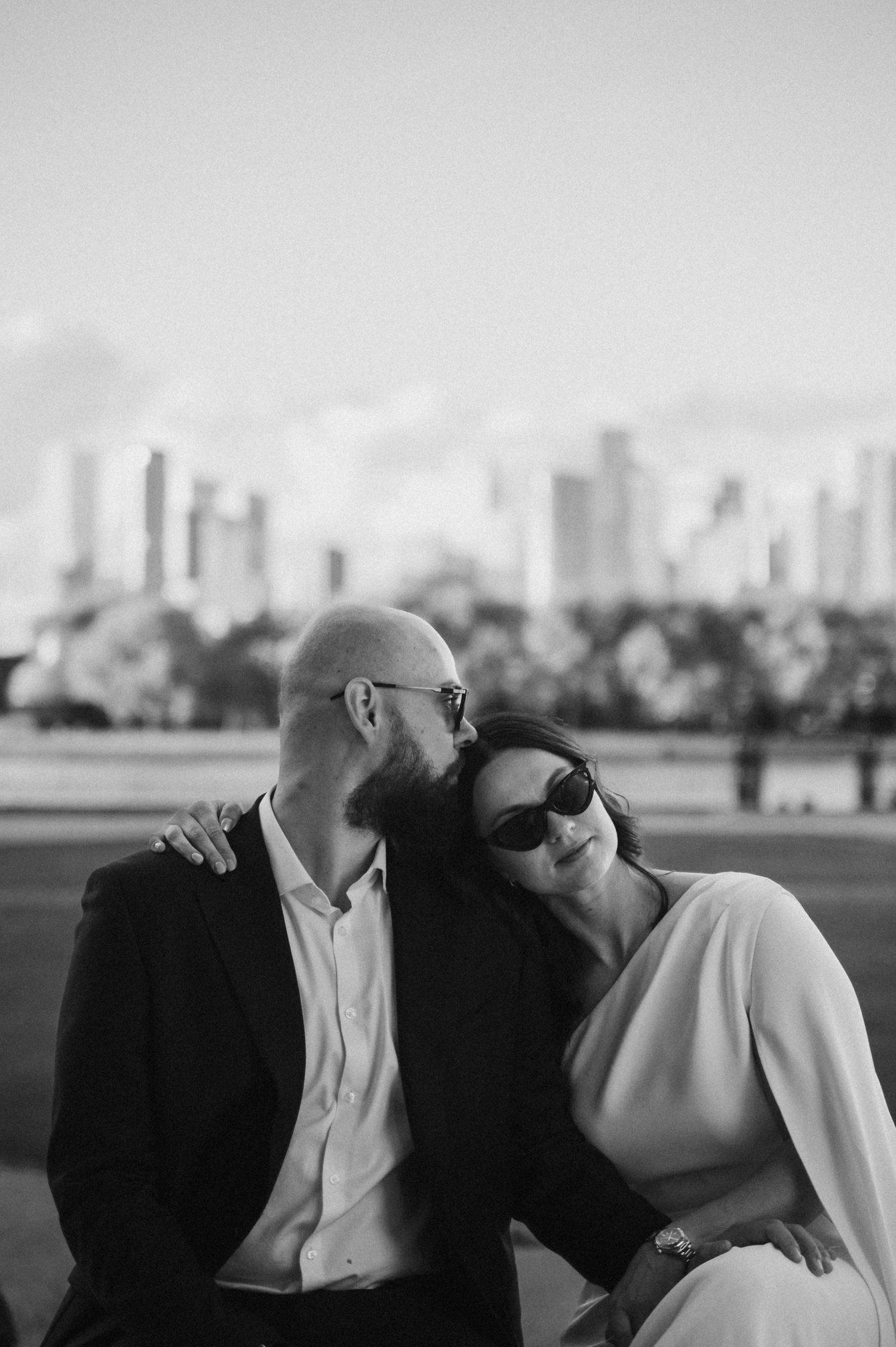 Romantic silhouette of couple against city skyline backdrop.