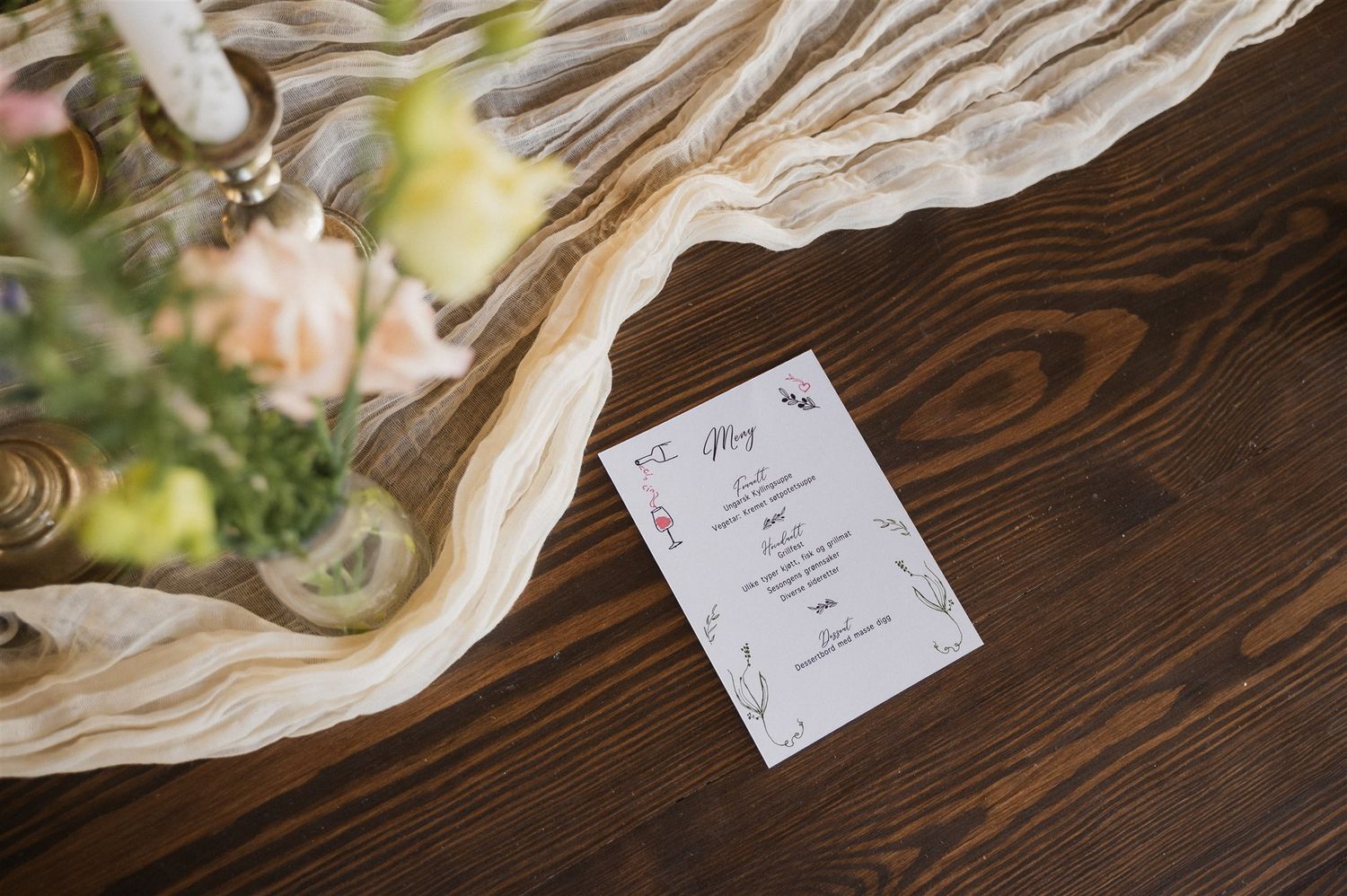 Elegant place settings with name cards and linens arranged on a rustic wooden table.