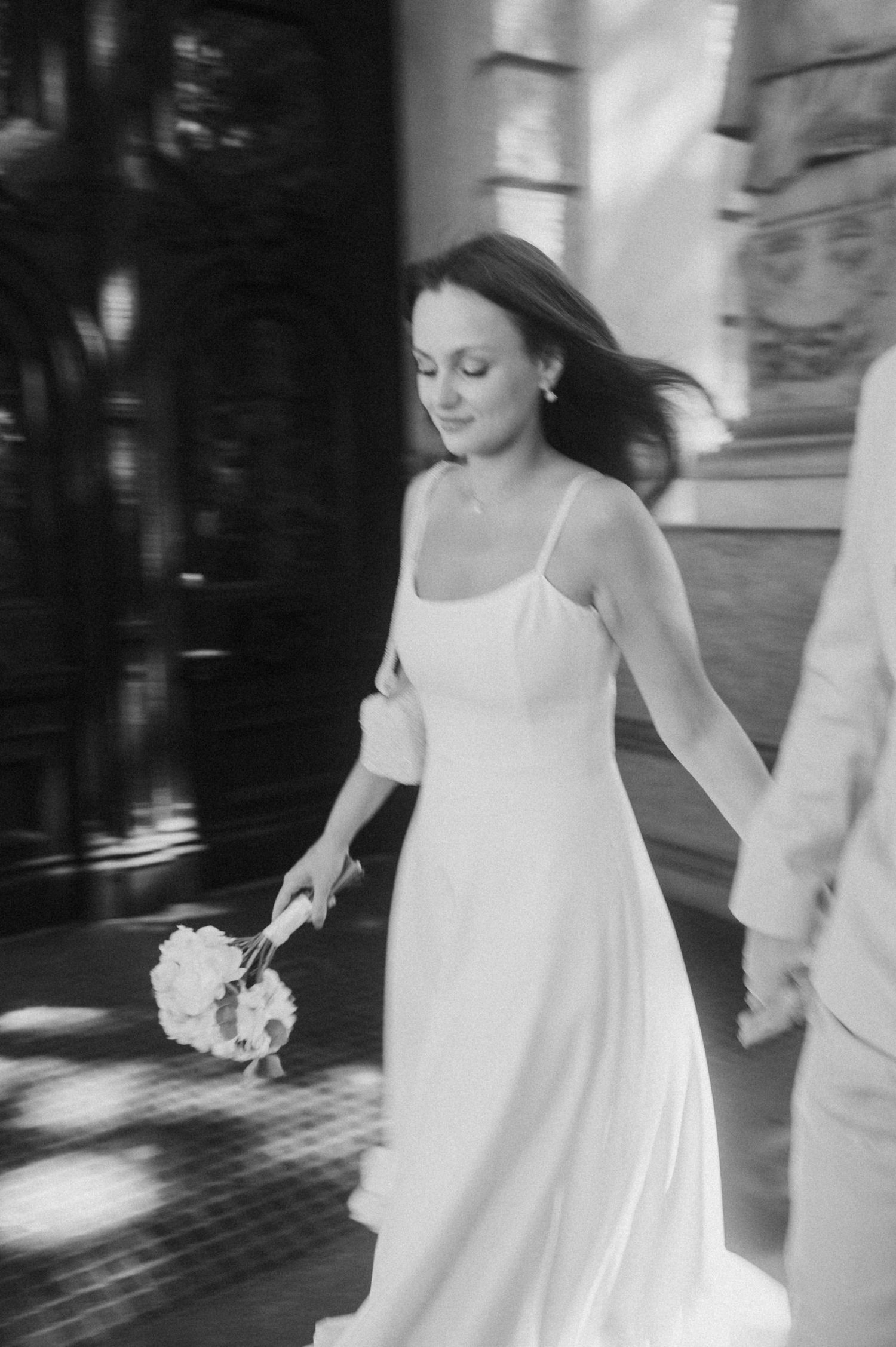 A black and white sequence of a couple dancing in elegant white and cream attire.