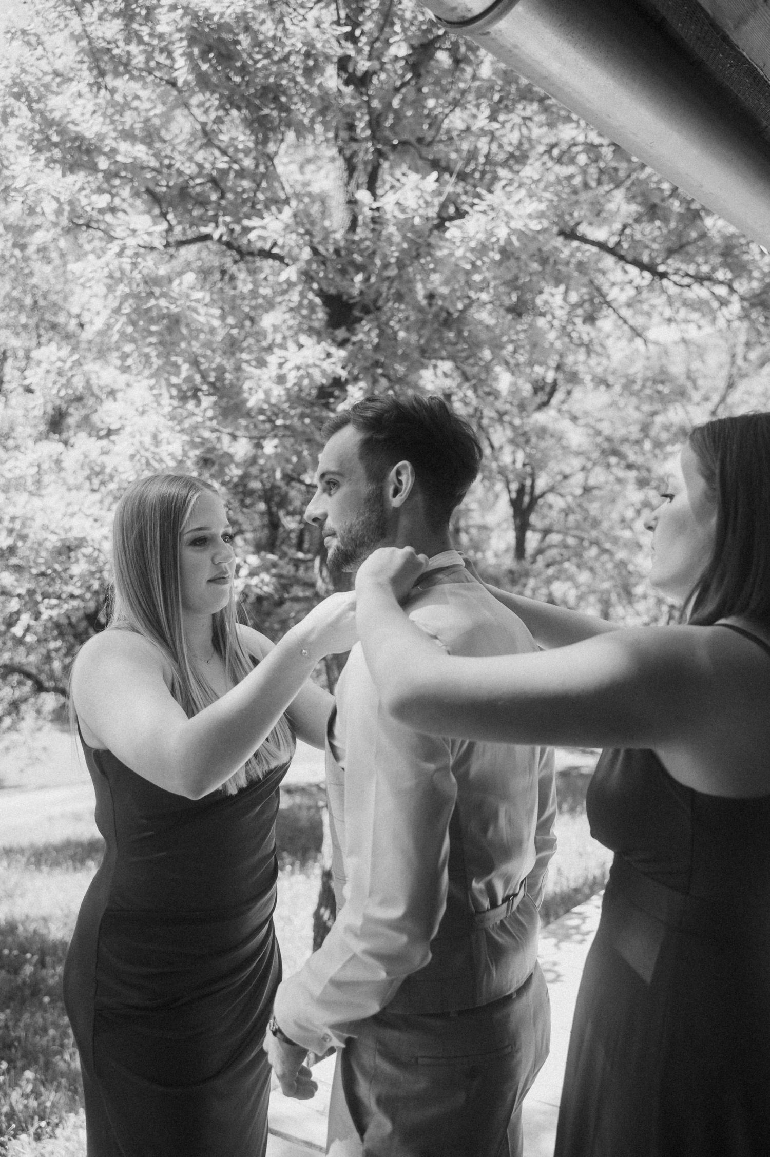 Black and white sequence showing wedding party members playfully posing together outdoors.