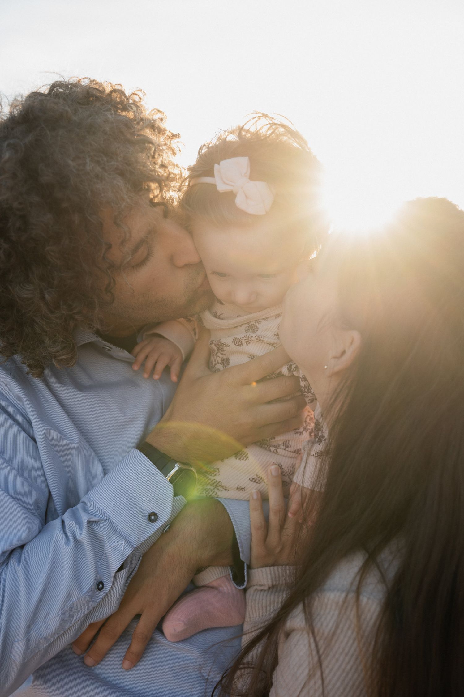 Couple sharing tender moments in warm sunlight with soft romantic glow.