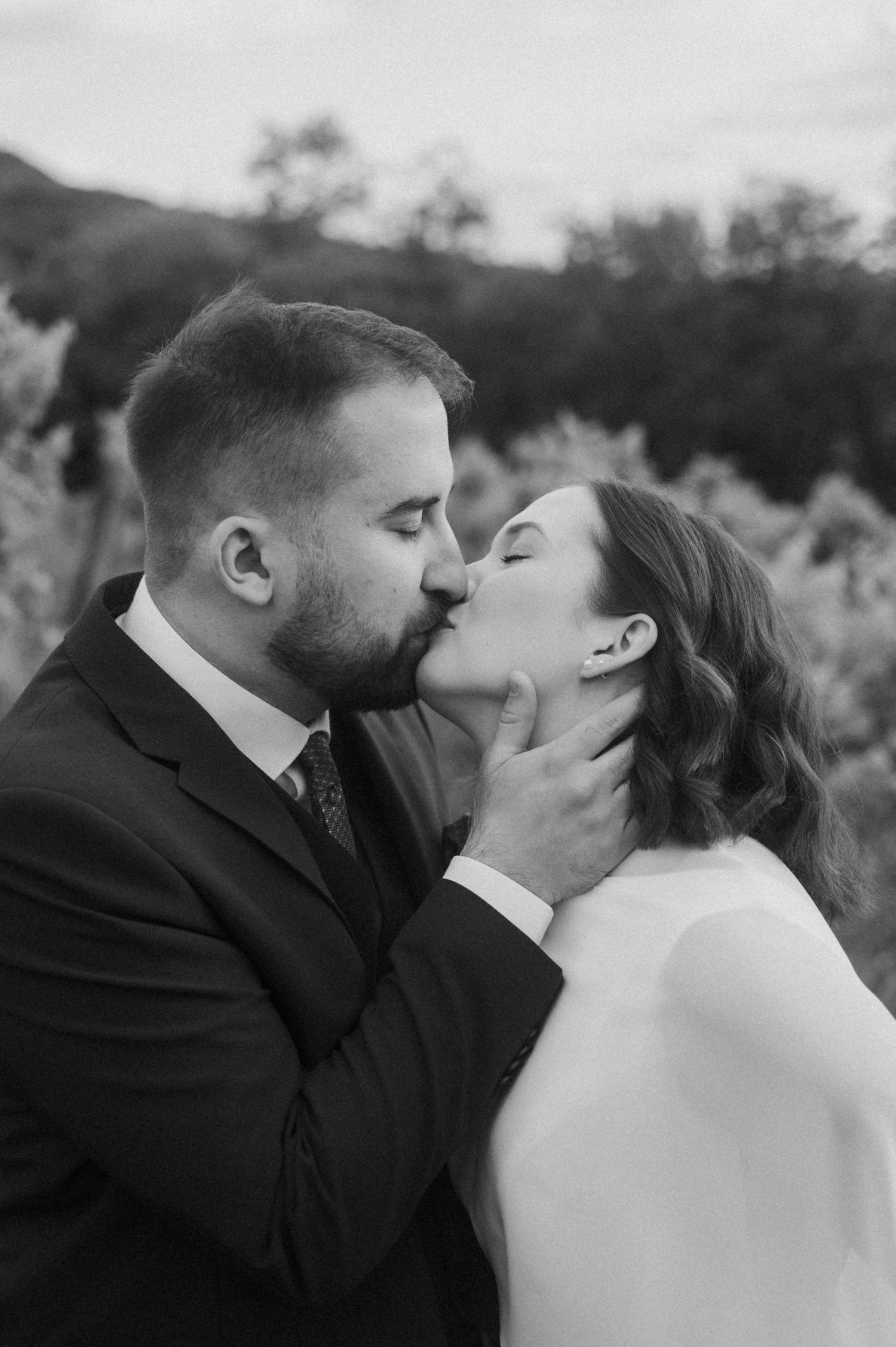 A romantic black and white photo sequence shows a couple sharing intimate kisses in an outdoor setting.
