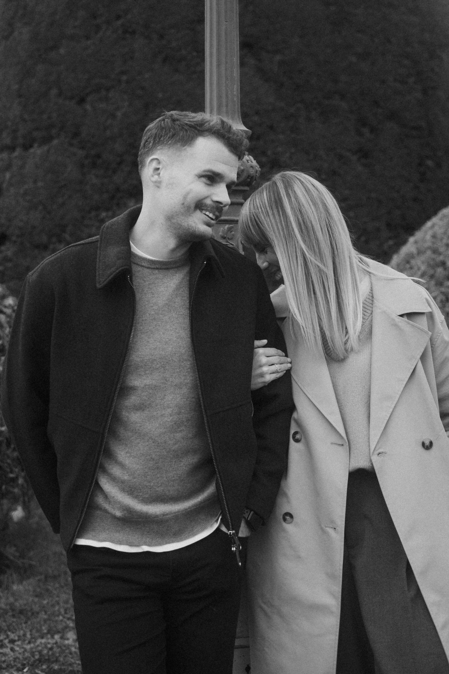 A romantic black and white photo series showing a couple embracing and sharing intimate moments outdoors.