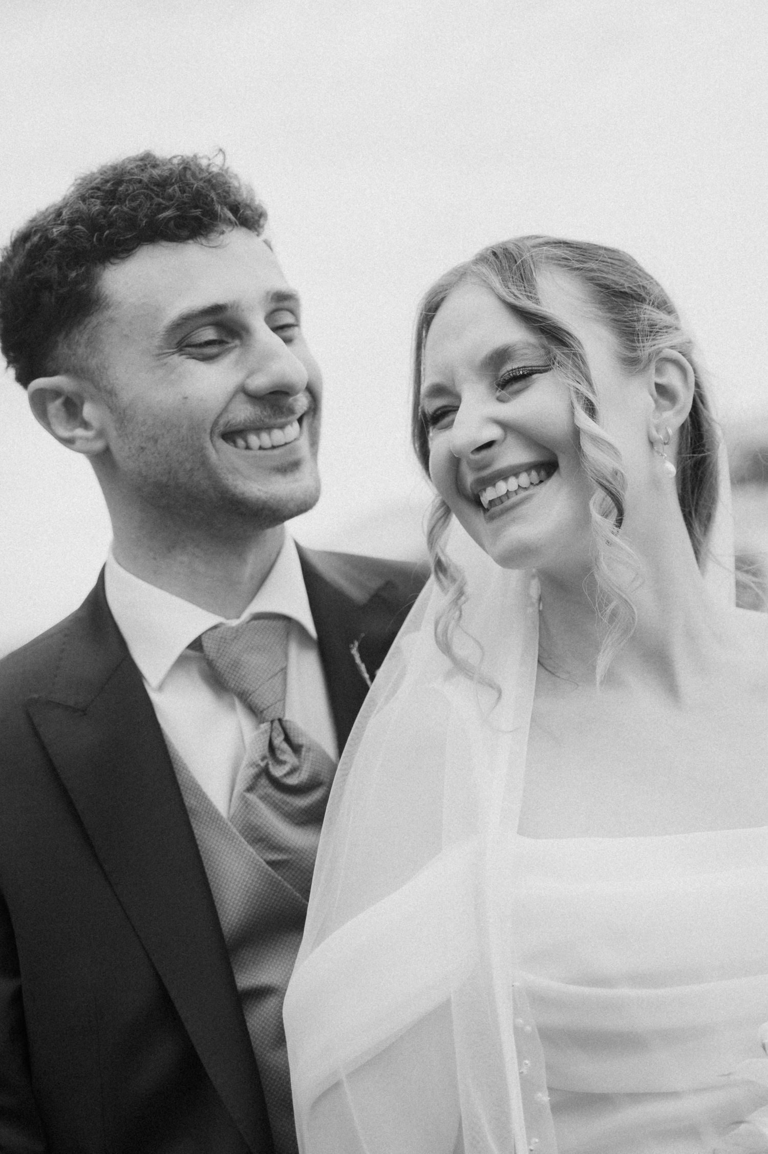 Black and white portrait of laughing bride and groom on their wedding day.