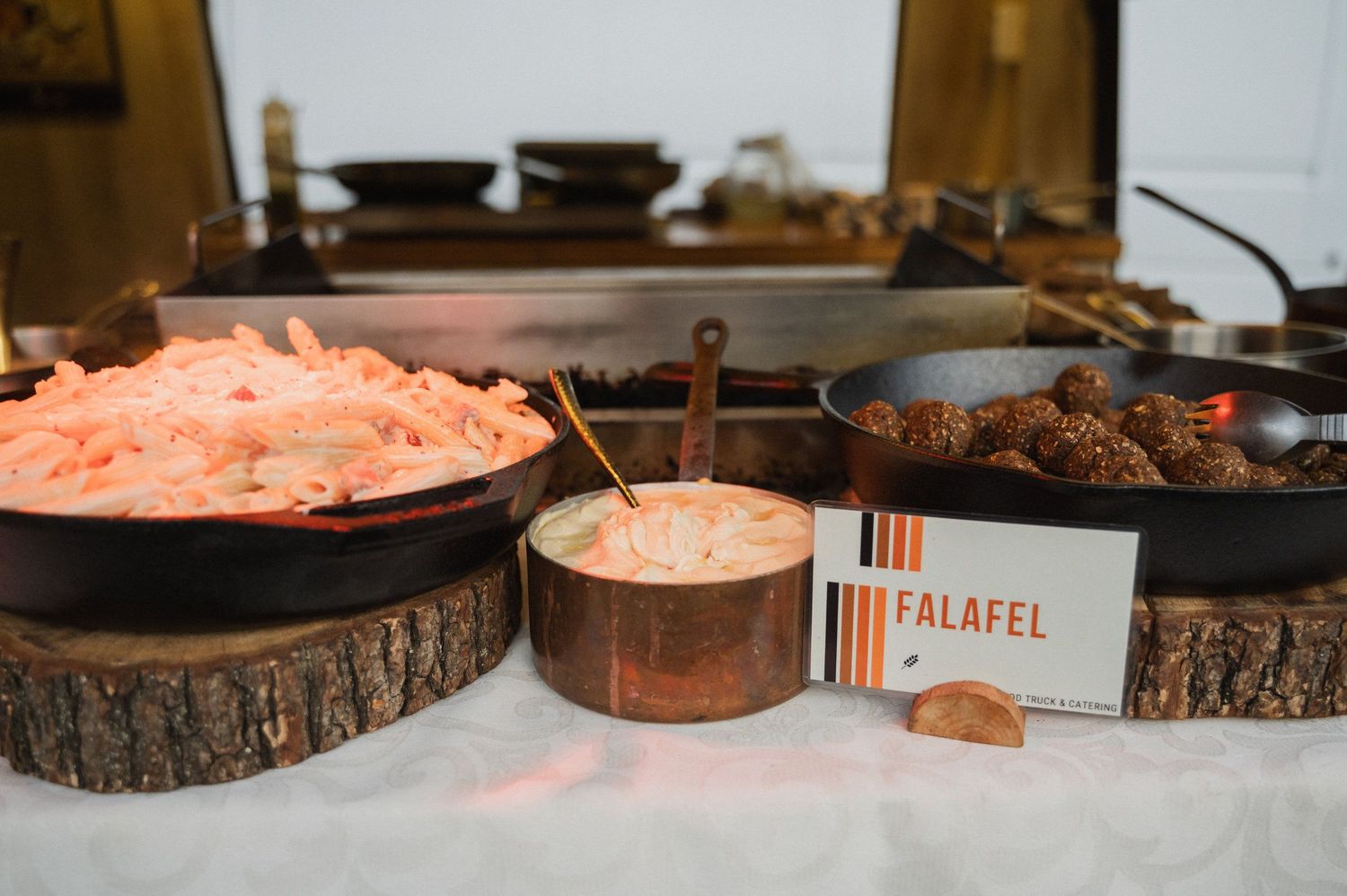 A buffet table displays Mediterranean dishes including falafel, hummus, and various Middle Eastern appetizers.