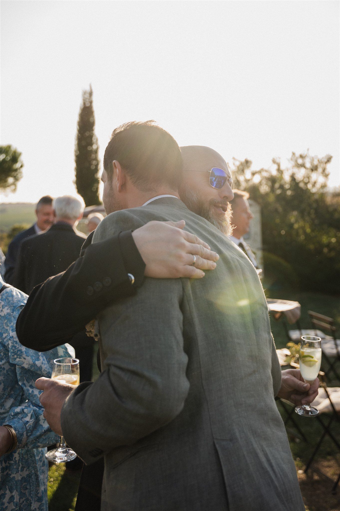 Emotional embrace captured during sunset at outdoor wedding celebration.
