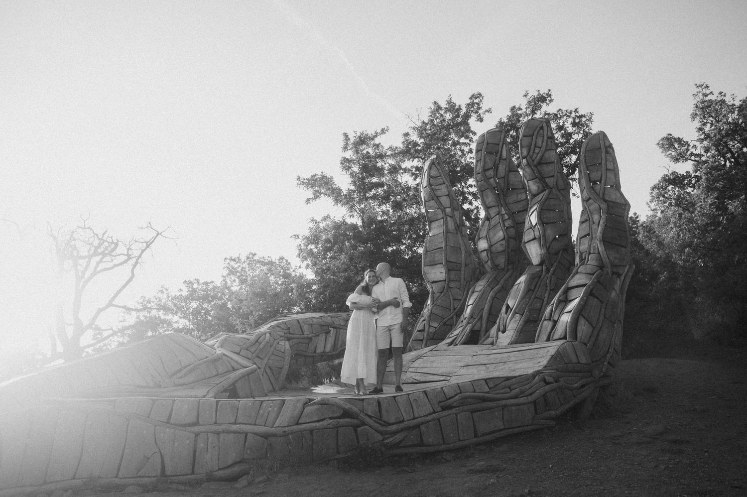 A panoramic black and white photograph shows people gathered on a hilltop overlooking a misty landscape.
