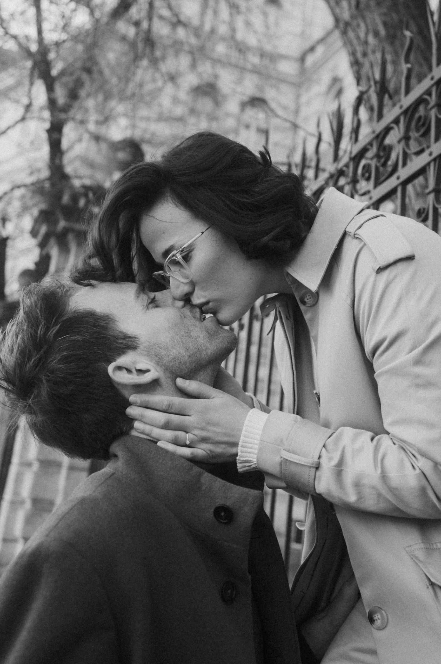 A romantic black and white photo series showing a couple kissing on a balcony.