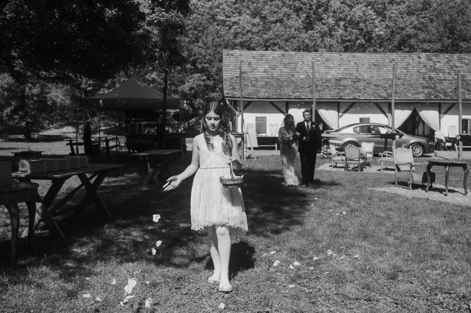 A series of black and white wedding photos showing outdoor ceremony moments and celebrations in a garden setting.
