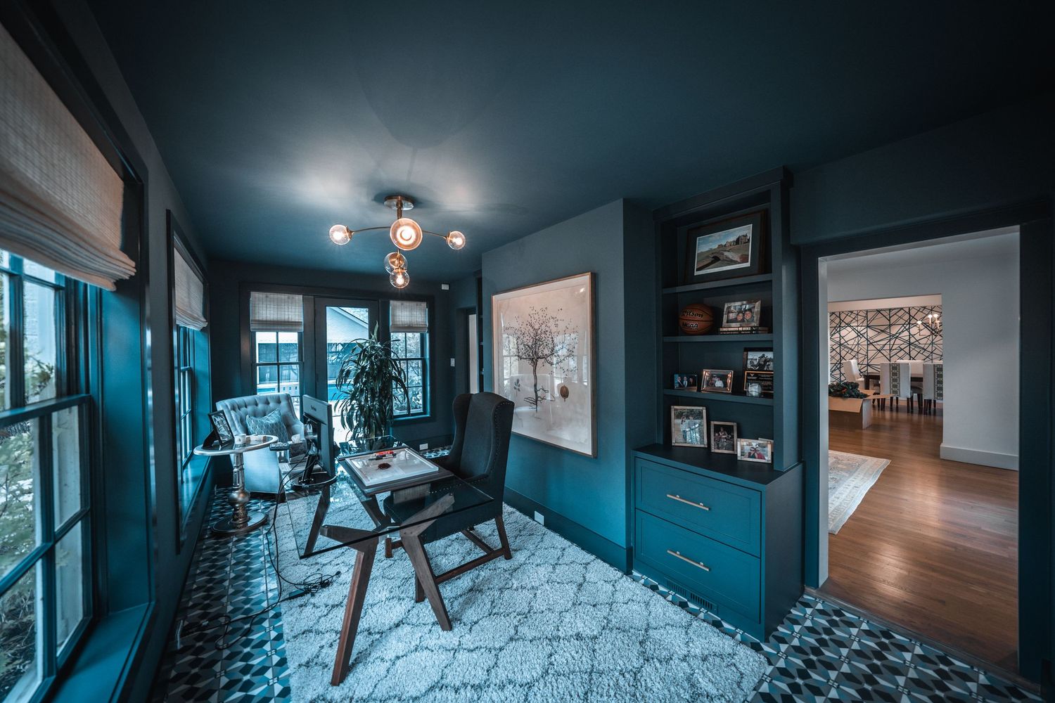 Modern home interior with blue tinted lighting showcasing hallway and exercise equipment.