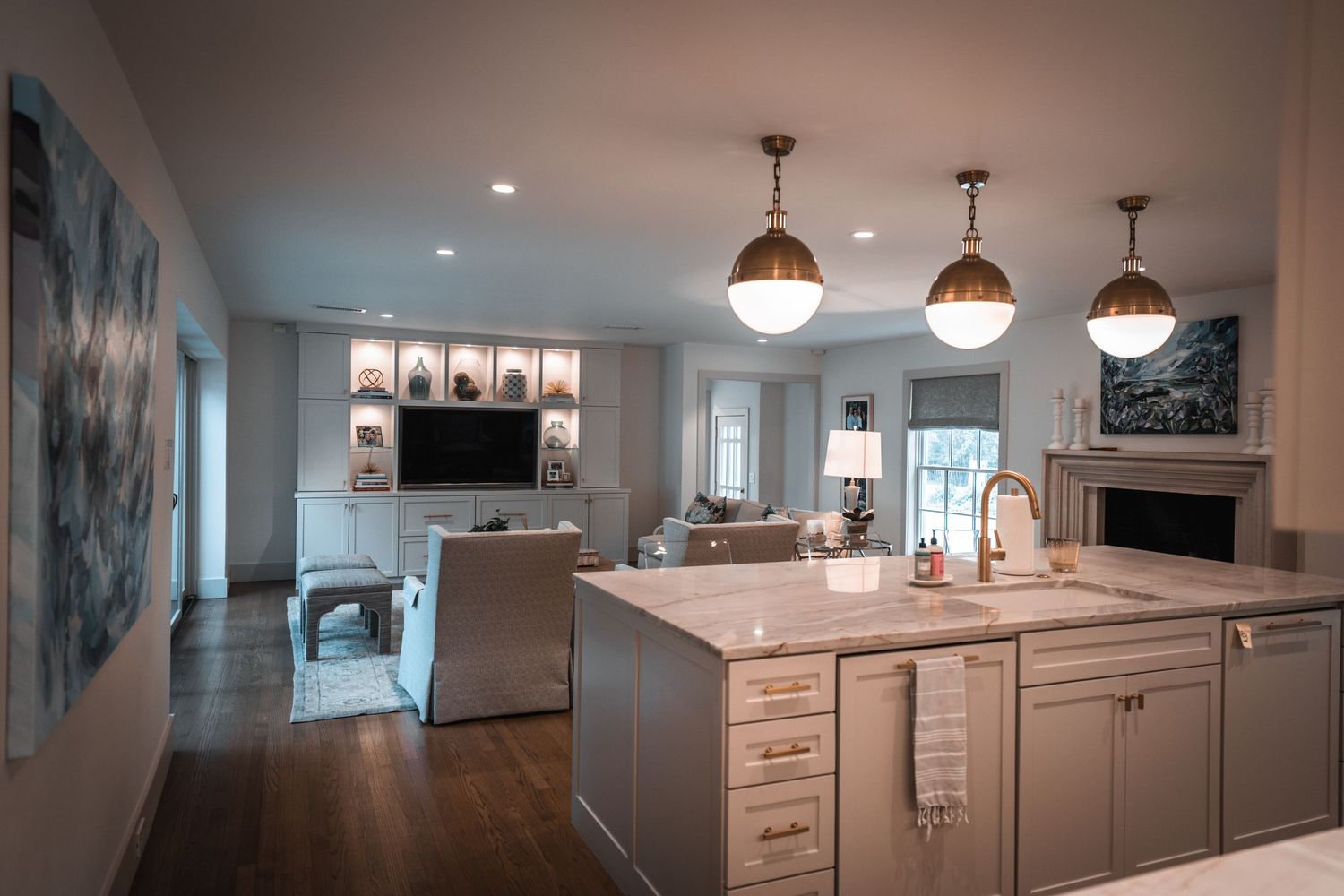 Renovated basement space featuring white cabinetry and pendant lighting in modern design.