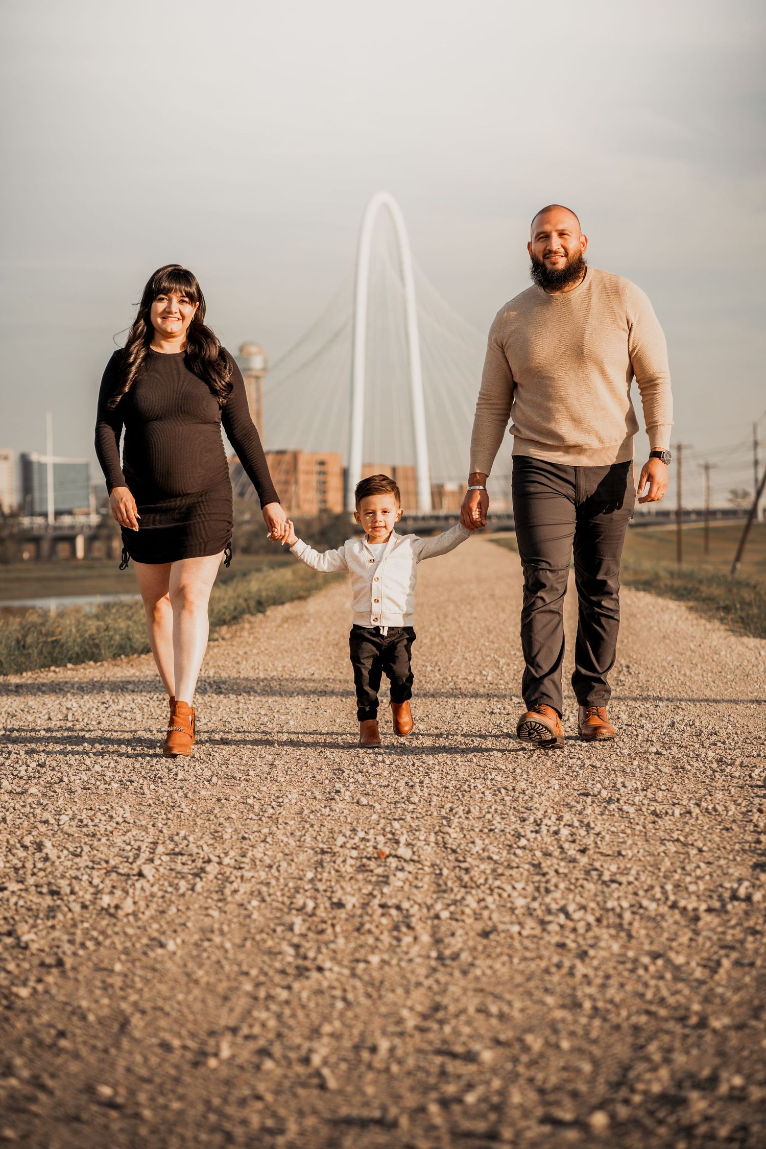 Low angle shot of people walking on gravel path with city buildings in background.