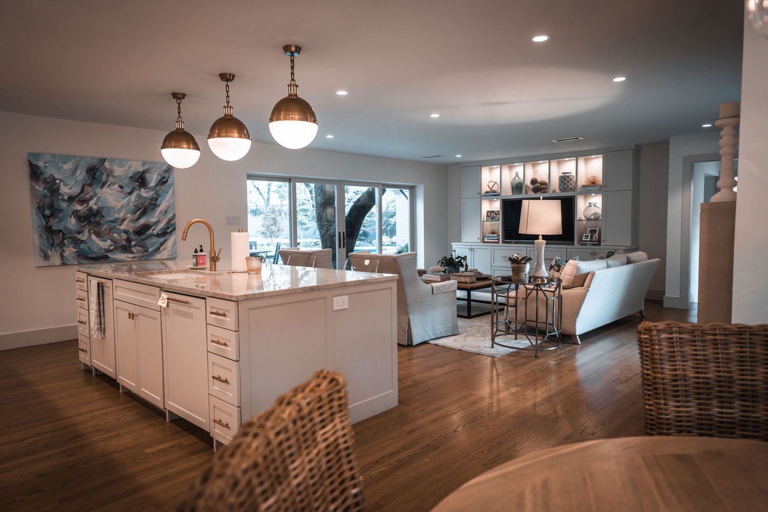 Open concept basement renovation with white cabinets and pendant lighting.