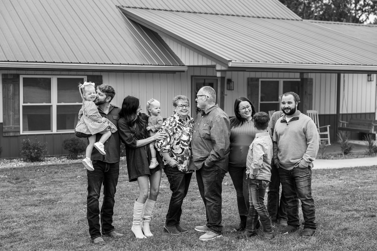 extended family looking and smiling at each other together in fall family photos in Mid Missouri
