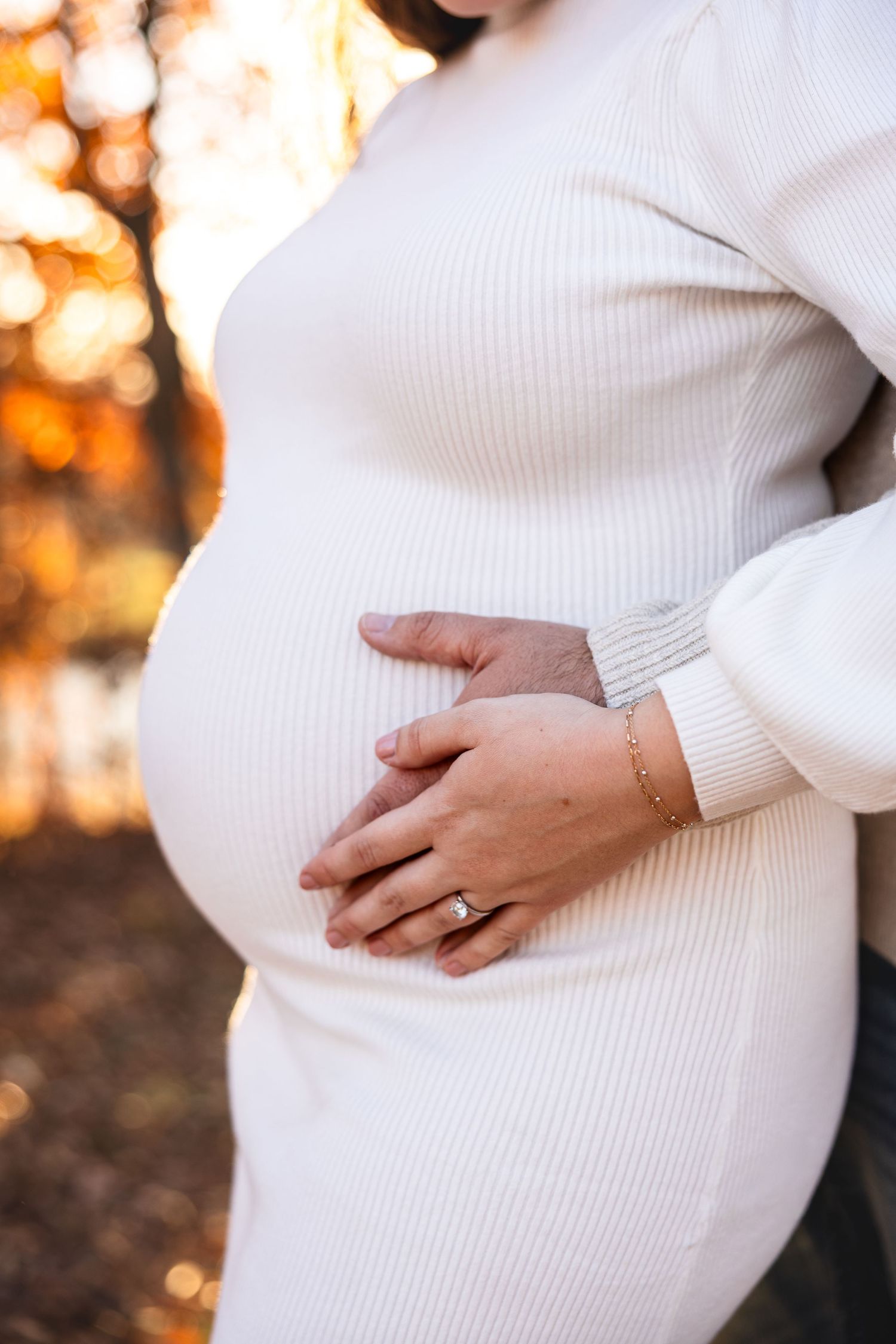 maternity photo session showing mom's pregnancy bump with mom and dad holding mom's pregnant belly fall sunset photos