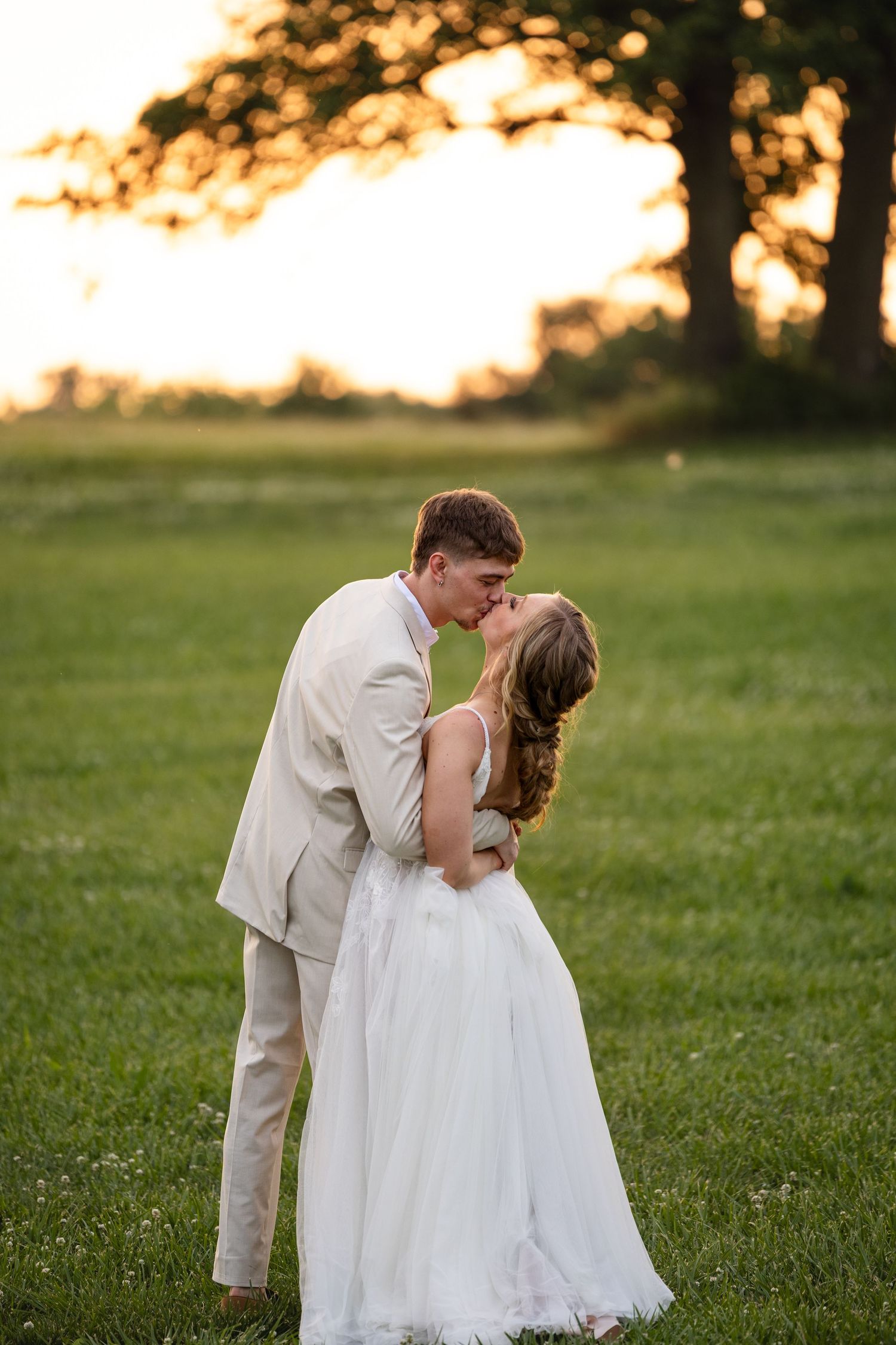 bride and groom holding hands kissing each other sunset portraits wedding day in boonville missouri wedding