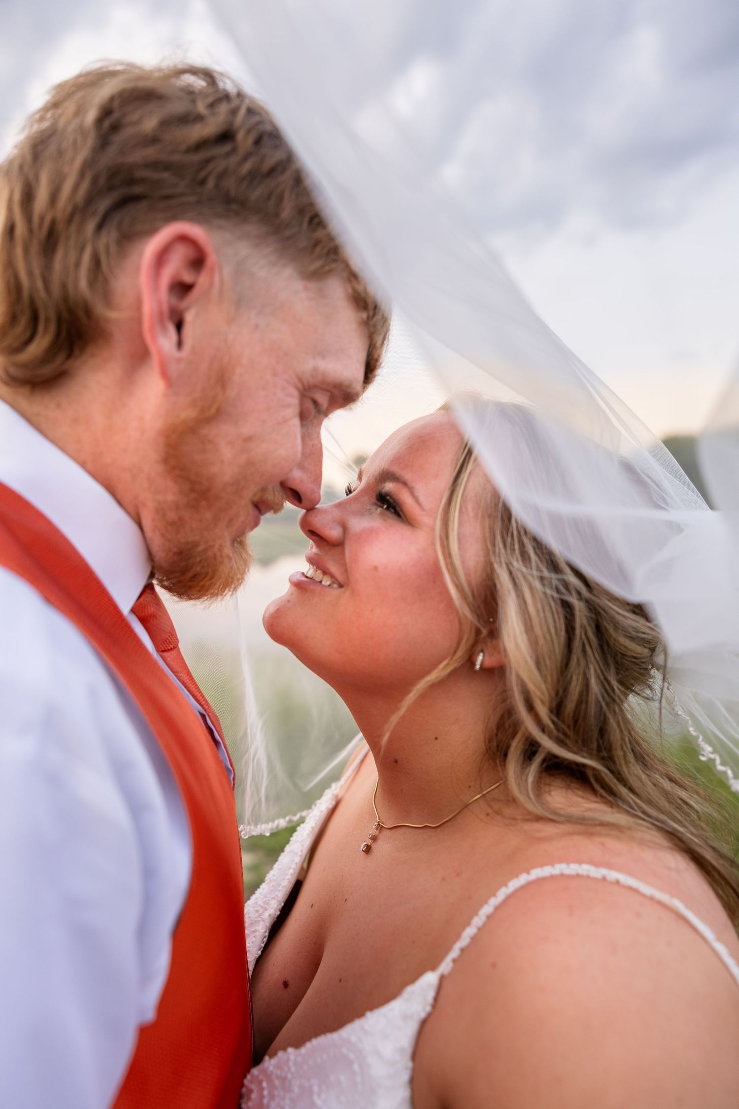bride and groom looking at each other with faces close together under bride's veil for bride and groom portraits in Moberly MO wedding