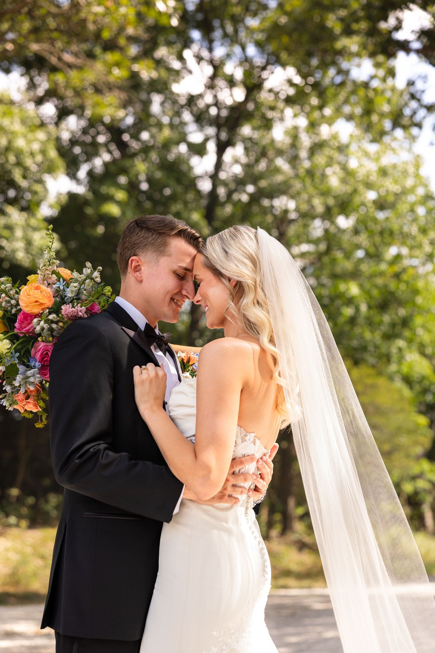 bride and groom facing each other and holding each other for wedding photos in STL MO showing bridal bouquet and veil