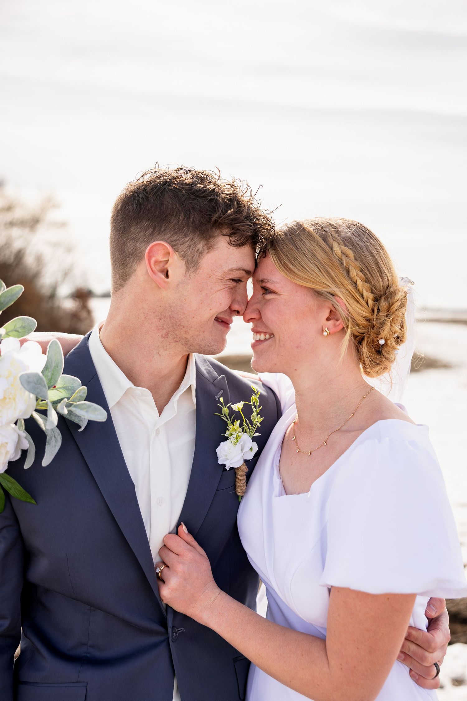 bride holding groom's jacket and foreheads together smiling at each other on wedding day for wedding photos in northern Missouri