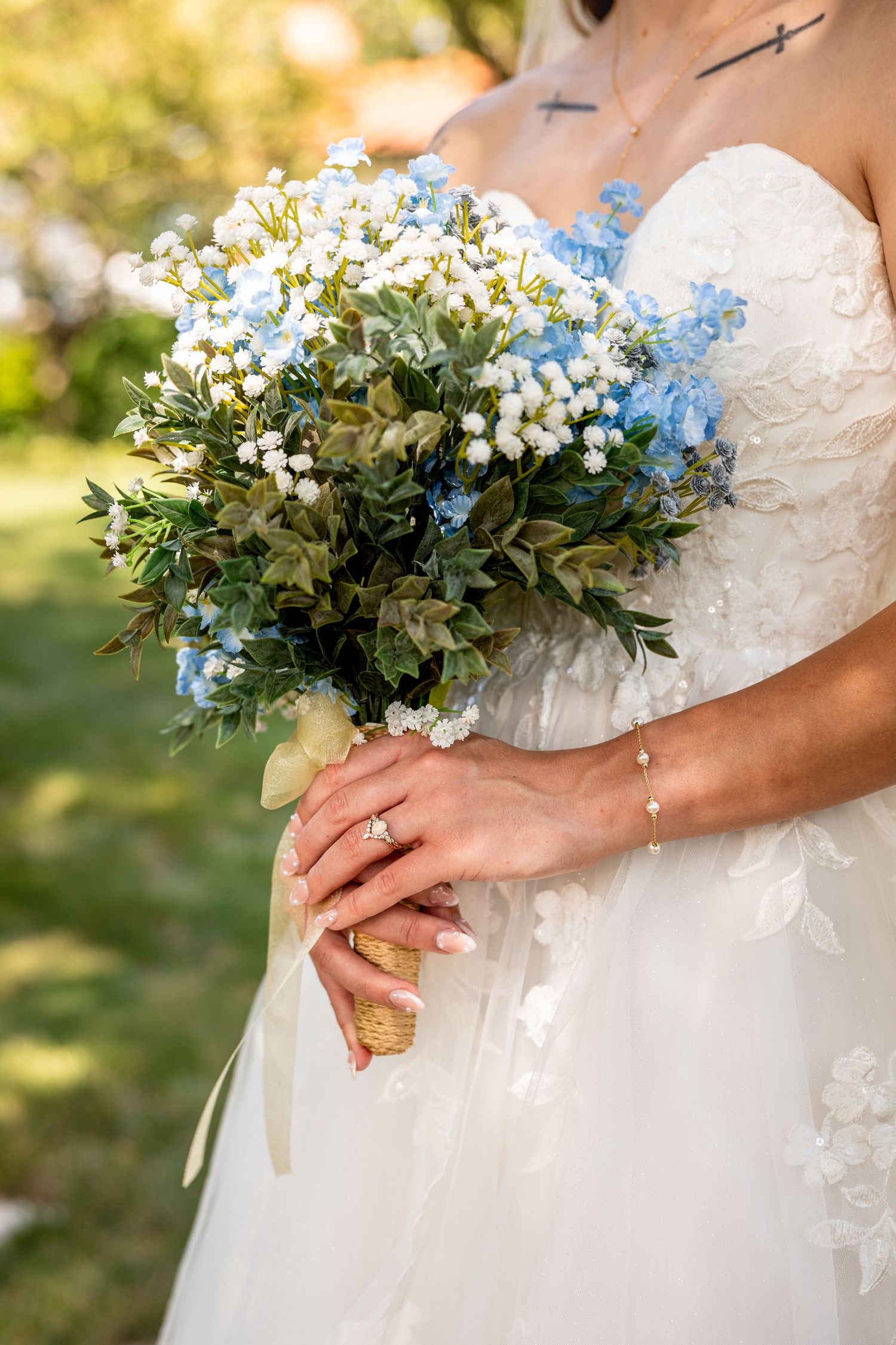bride holding wedding bouquet in wedding dress highlighting jewelry details for wedding photos in Kansas City Missouri