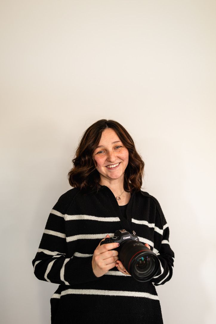 photographer Courtney Burrus holding camera and smiling for wedding photography and family photography near Mid Missouri Moberly & Columbia