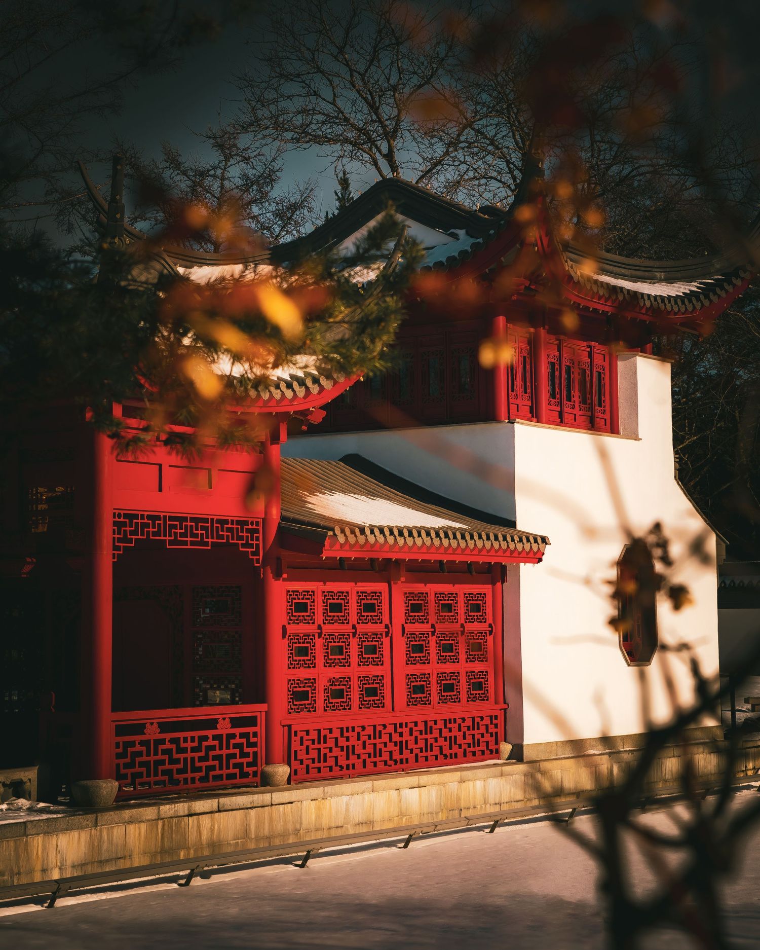 Traditional Chinese red wall architecture with ornate patterns photographed at sunset.