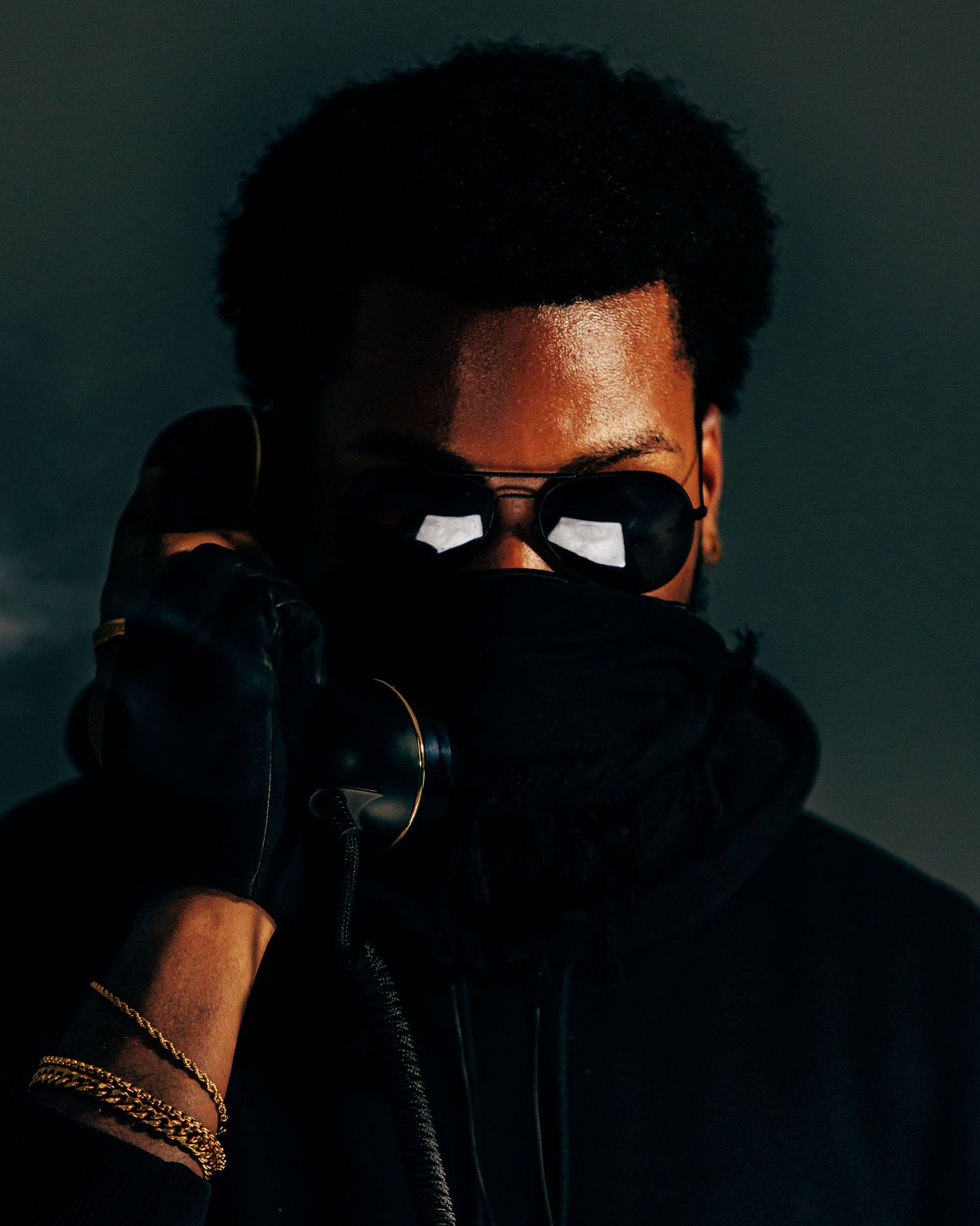 Dark silhouetted portrait series showing a figure wearing sunglasses against moody lighting.