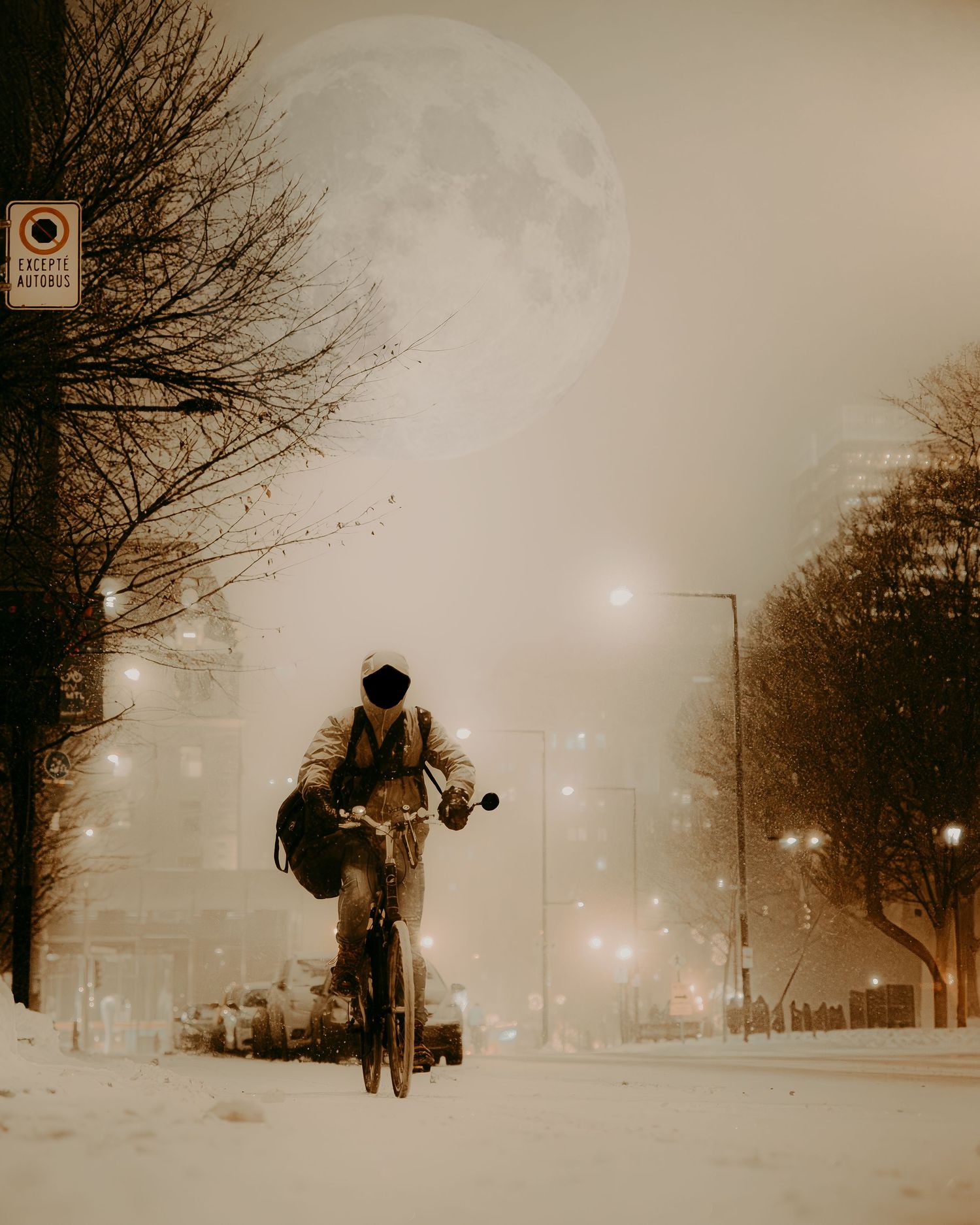 A lone cyclist rides through a snowy winter street at night with a large full moon glowing in the misty sky.