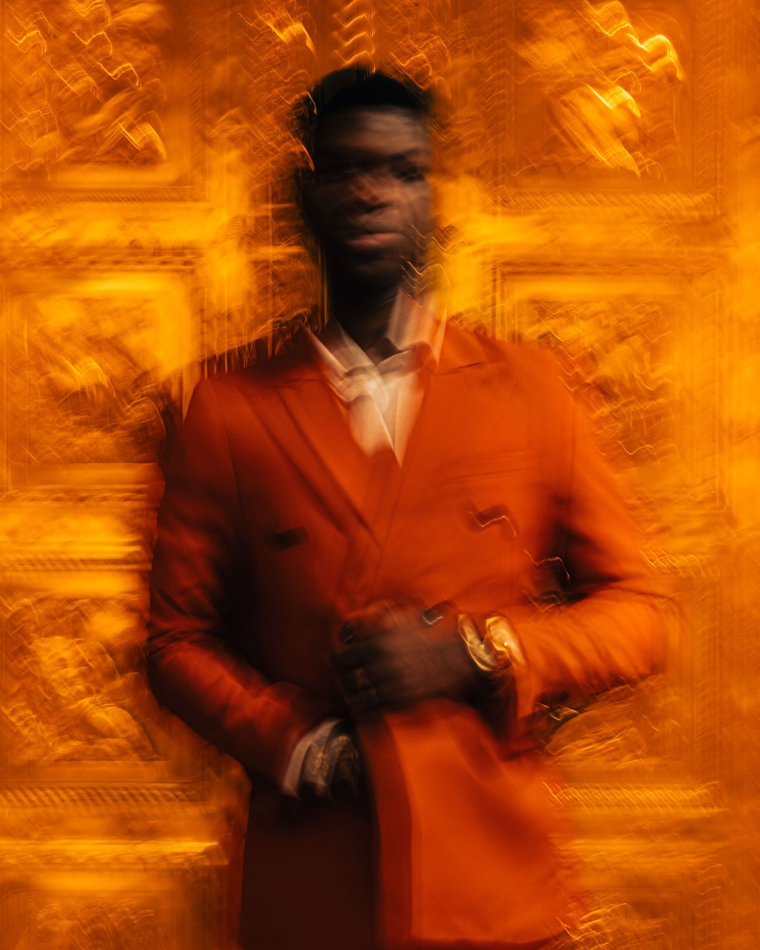 Abstract motion blur portrait in vibrant orange tones creates artistic effect.