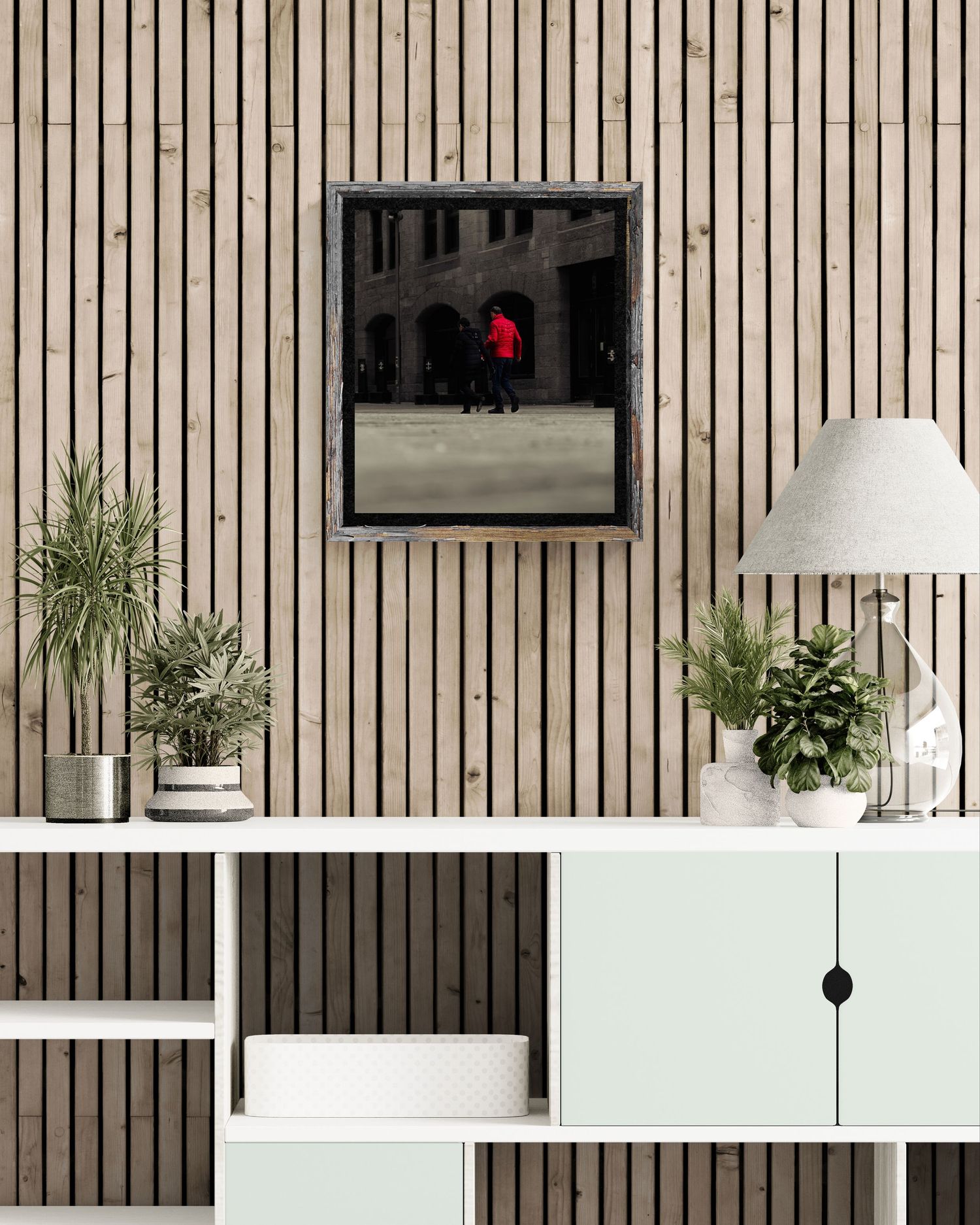 Modern living room with wood slat wall, framed red figure artwork, mint green cabinet, and decorative plants on white shelving.