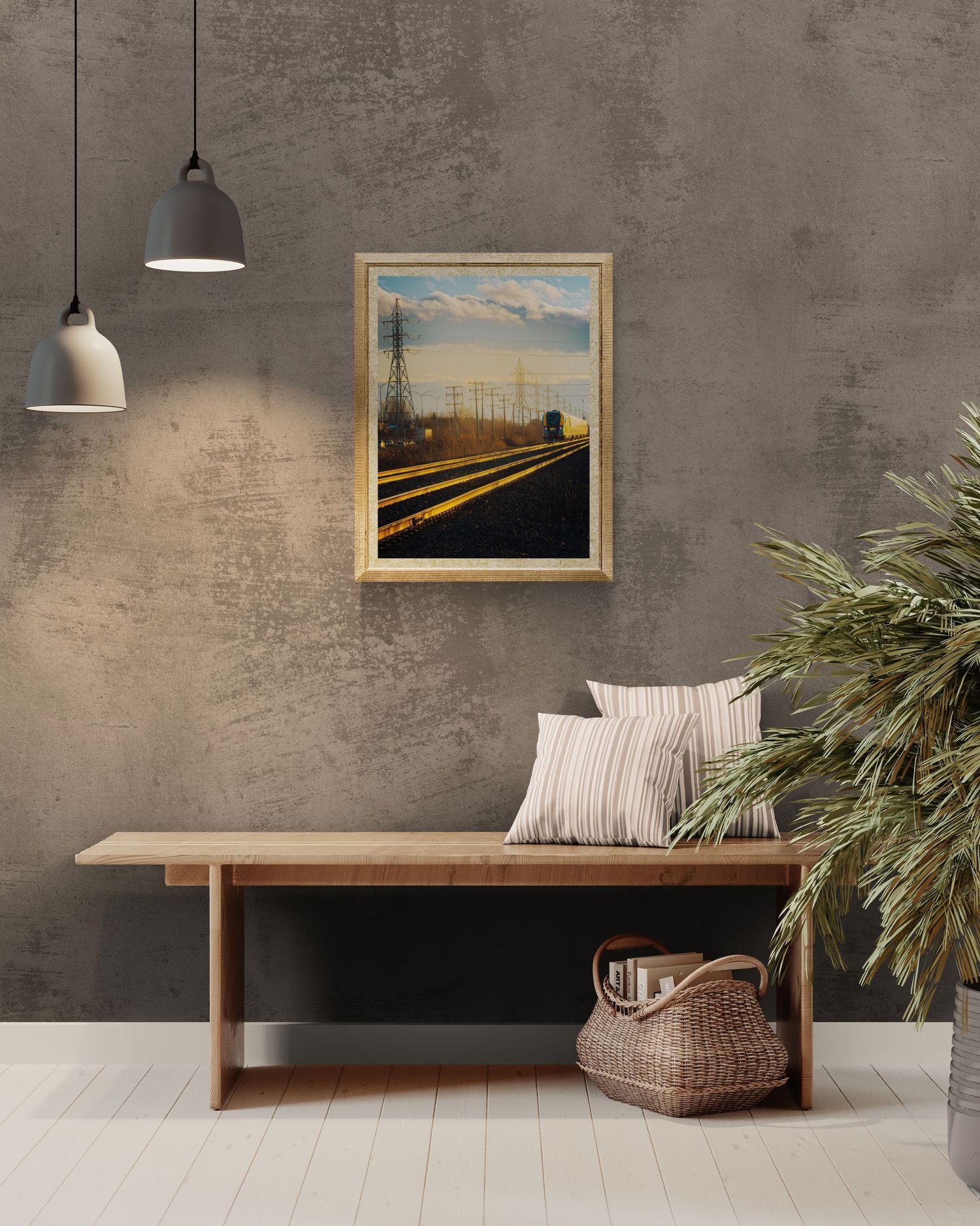 Framed railroad track painting with golden light hung on textured gray wall above wooden bench with wicker basket.