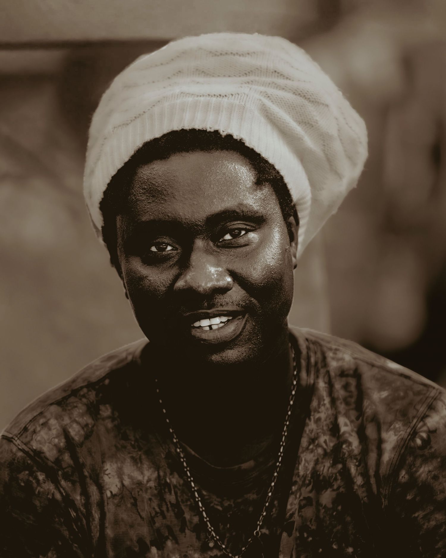 A black and white portrait series showing expressions of joy and laughter in traditional head wraps and clothing.